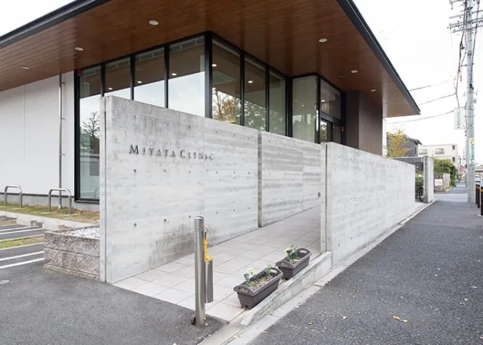 宮田医院の外観。コンクリート塀に MIYATA CLINIC の表示